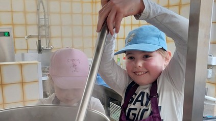 Kind am großen Kochtopf