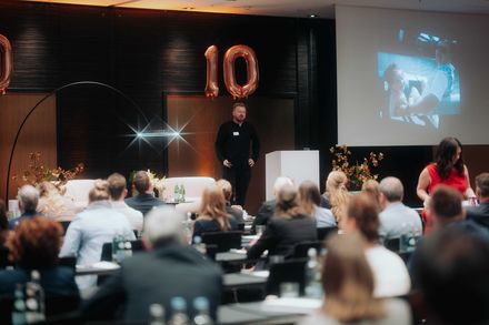 Joshua Keck spricht beim Fair Job Hotels Partnertreffen 2026 auf der Bühne über KI-Sichtbarkeit, digitale Auffindbarkeit und Arbeitgeberkommunikation.