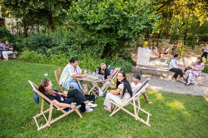 Teilnehmer des UPNXT Hospitality Festivals 2026 tauschen sich auf der Außenfläche der Veranstaltungslocation in Berlin in lockerer Festivalatmosphäre aus.