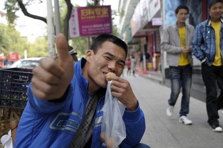 Mann isst auf Straße