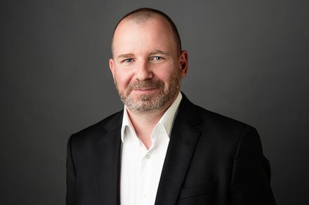 Porträt von smartments-Geschäftsführer Jens Kindschuh im schwarzen Sakko