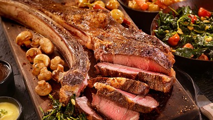Ein Holzbrett mit frisch aufgeschnittenem, bereits zubereitetem Fleisch