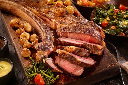 Ein Holzbrett mit frisch aufgeschnittenem, bereits zubereitetem Fleisch