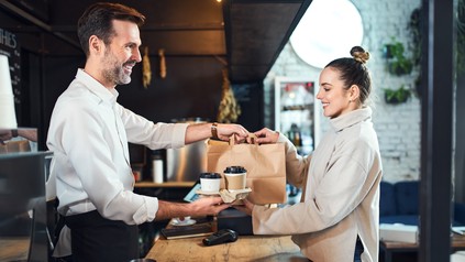 Essen zum Mitnehmen wird an der Theke überreicht
