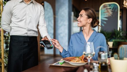 Frau beim bezahlen im Restaurnat