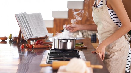Frau mit Kochbuch in der Küche