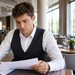 Mitarbeiter im Gastgewerbe prüft einen Arbeitsvertrag in einem Hotelrestaurant.