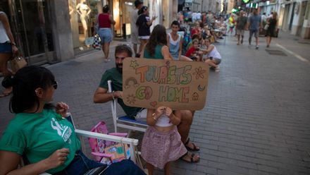 Demonstranten auf Mallorca protestieren mit Plakaten gegen die Folgen des Massentourismus.