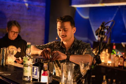 Bartender bereitet bei Bar Wars einen Drink mit verschiedenen Zutaten zu.