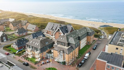 Luftaufnahme des Strandhotel Sylt in Westerland mit Dünen, Strand und Nordsee im Hintergrund.