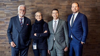 Heiner, Renate, Sebastian und Matthias Finkbeiner stehen gemeinsam vor einer Wand aus Holzelementen