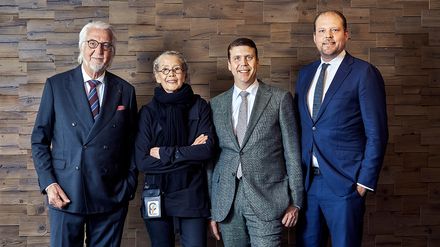Heiner, Renate, Sebastian und Matthias Finkbeiner stehen gemeinsam vor einer Wand aus Holzelementen