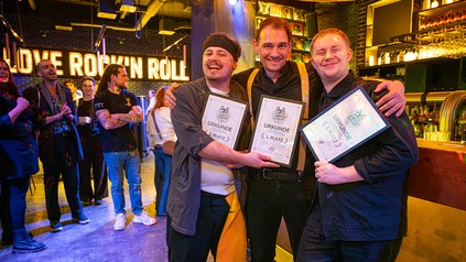 Die drei Platzierten von Bar Wars 2.0 stehen im Classic Rock Café Stuttgart mit ihren Urkunden
