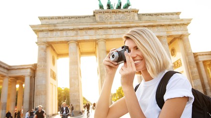 Touristin mit Kamera vor dem Brandenburger Tor