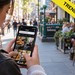 junge Frau blickt ind er City auf ihr Handy bei TikTok