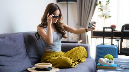 Junge Frau im Hotelzimmer mit Handy