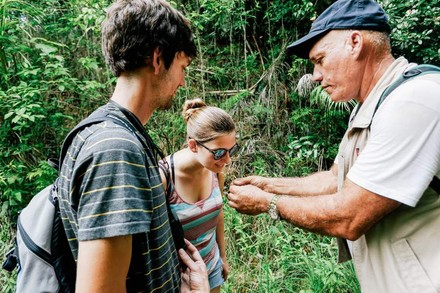 Zwei Touristen mit einem Führer im Wald