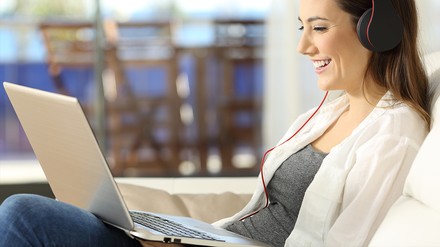 Frau mit Laptop im Hotelzimmer