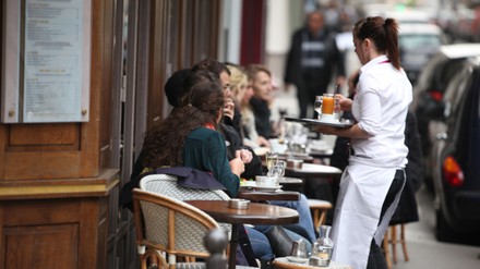 Kellnerin bringt Getränke an Tisch