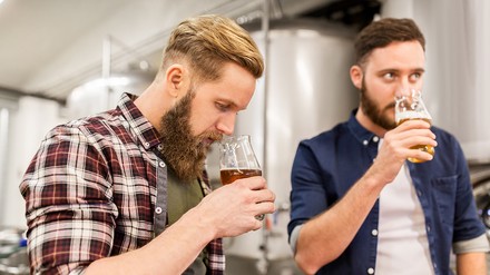 Zwei Männer in einer Brauerei probieren Craft Beer