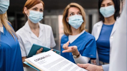 Gruppe von Ärzten und Schwestern mit Coronaverordnung
