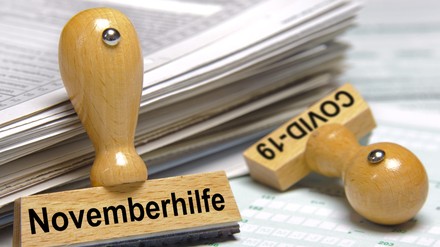 Stempel mit der Aufschrift Covid-19 und Novemberhilfe