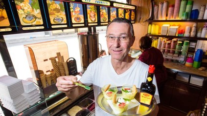 Uwe Hoffmann hält ein Tablett mit drei Eisbechern und einer Flasche Maggie Würze