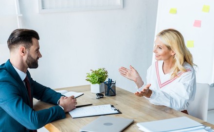 Bärtiger Recruiter unterhält sich mit Frau im Büro