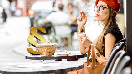 Eine Frau mit Zigarette am Straßencafé