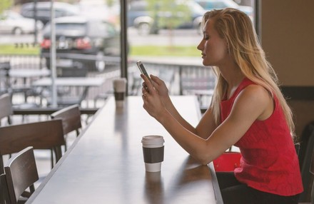 Frau mit Smartphone in Restaurant