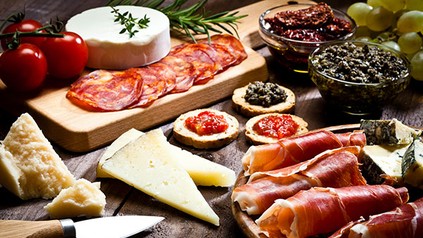 Delikatessen wie Schinken Salami, Käse und Antipasti liebevoll angerichtet