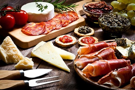 Delikatessen wie Schinken Salami, Käse und Antipasti liebevoll angerichtet