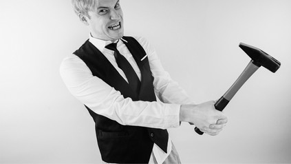 Kellner mit Hammer in der Hand und verrücktem Gesichtsausdruck