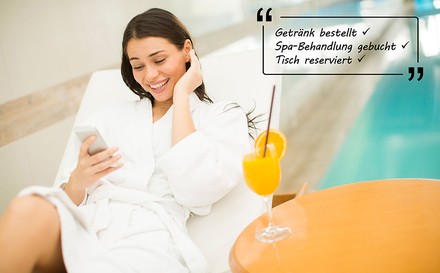 Junge Frau relaxt im Hotel-Spa und benutzt ein Handy.