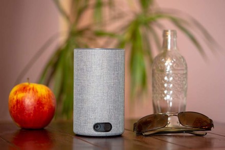 ALEXA in einem Hotelzimmer neben einem Apfel und einer Sonnenbrille