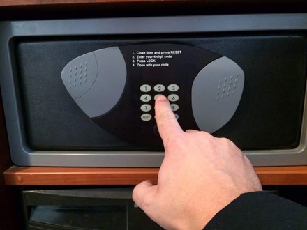 Mann drückt auf Knopf am Hotelsafe