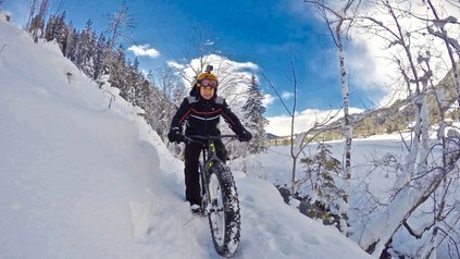 Mann mit Mountain Bike im Schnee