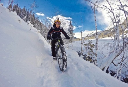 Mann mit Mountain Bike im Schnee