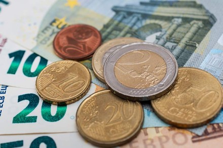 Geldscheine und Euromünzen liegen auf einem Tisch