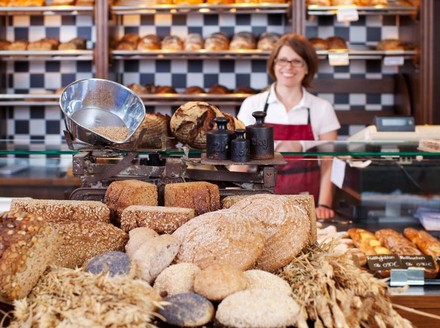 Bäckerin in Bäckerei vor Brot