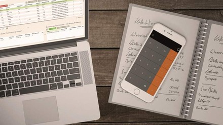 Ein Laptop und ein Handy als Hilfsmittel bei der Kalkulation