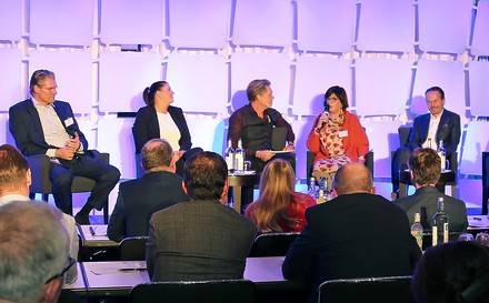 Eine Gruppe Teilnehmer diskutiert auf einem Podium