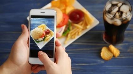 Foodblogger fotografiert seinen Burger