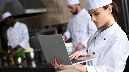 Eine Köchin mit Laptop