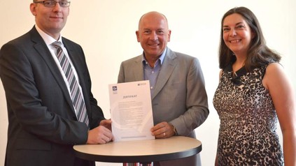 Drei Personen präsentieren das Zertifikat zur Unterstützung der Initiative Ausbildung mit Qualität
