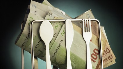 Ein Geldbündel neben einem Besteck