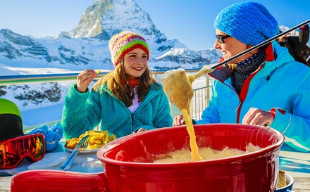 Skifahrer beim Fondue-Essen