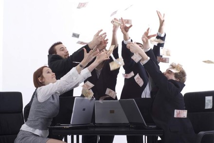 Einige Geschäftsleute versuchen sitzend vom Himmel fallende Geldscheine zu fangen