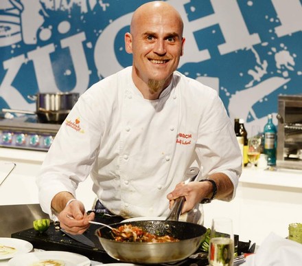 Ralf Zacherl lächelt und kocht Essen in Pfanne