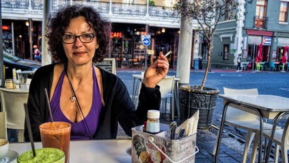 Frau mit Zigarette sitzt in einem Cafe